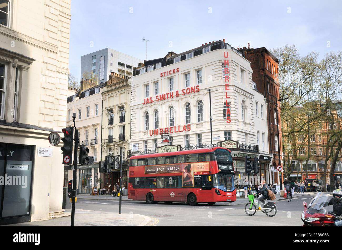 Autobus rosso a due piani che passa accanto al famoso negozio di ombrelli James Smith and Sons, classificato Grade II, a New Oxford Street. Jas. Smith & Sons Foto Stock