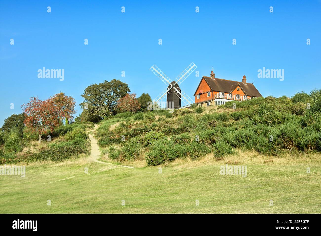 Reigate Heath Windmill (ora convertito in chiesa) accanto al circolo sul Reigate Heath Golf Club in una giornata di sole, Surrey, Inghilterra, Regno Unito. Mulini a vento Foto Stock