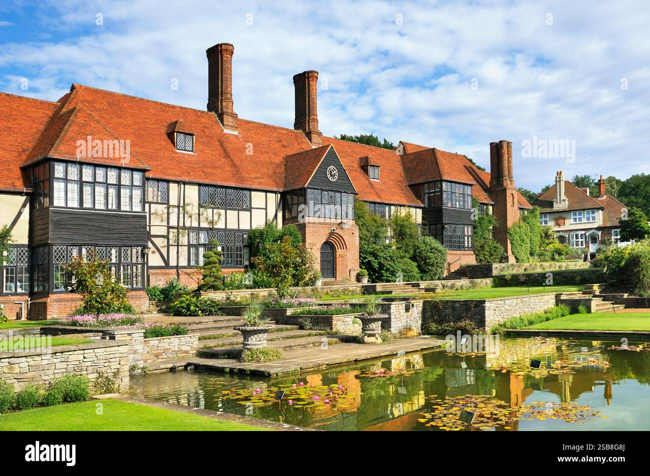 L'edificio del maniero Old Laboratory che si affaccia sul canale Jellicoe, RHS Wisley Gardens, Woking, Surrey, Inghilterra, REGNO UNITO. RHS Garden Wisley in estate Foto Stock
