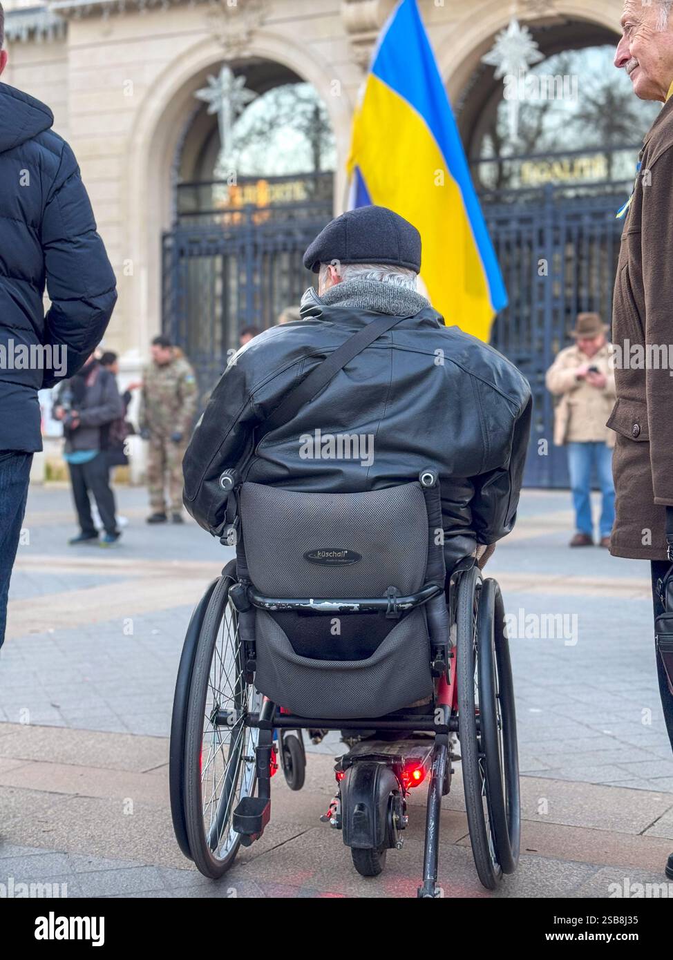 L'utente su sedia a rotelle partecipa a una manifestazione che sostiene l'Ucraina in inverno Foto Stock