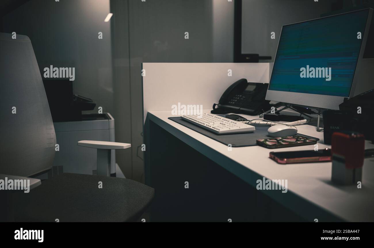 Dettagli del luogo di lavoro in ufficio, sedia vuota e tavolo con computer e attrezzature per ufficio. Foto Stock