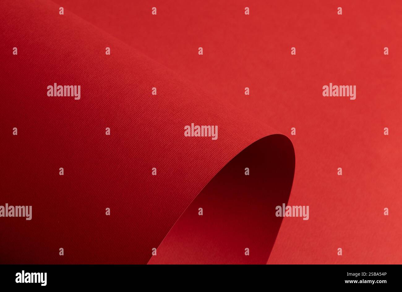 Sfondo in carta rossa con una texture opaca e toni morbidi. Le audaci tonalità rubino e cremisi creano una superficie elegante, elegante e moderna con un arredamento pulito Foto Stock