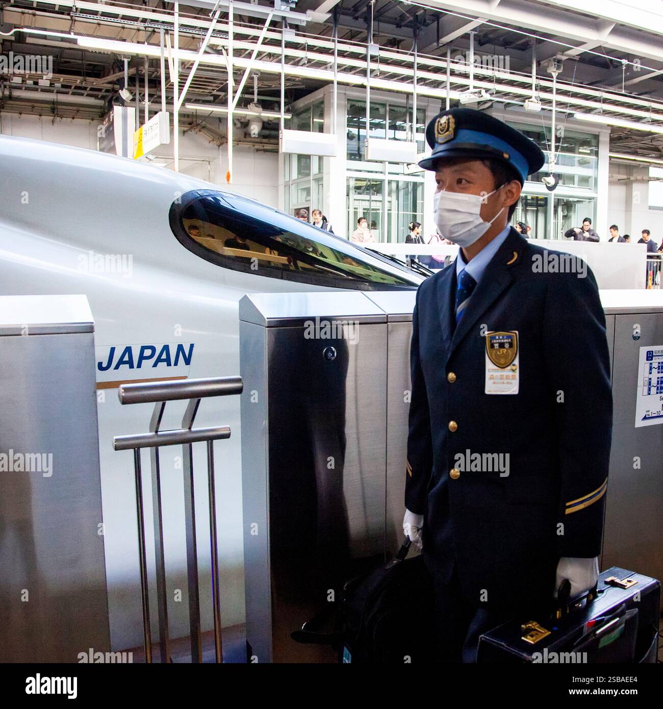 Un ingegnere ferroviario passa davanti a un treno superveloce Shinkansen N700 alla stazione di Shin-Osaka. Foto Stock
