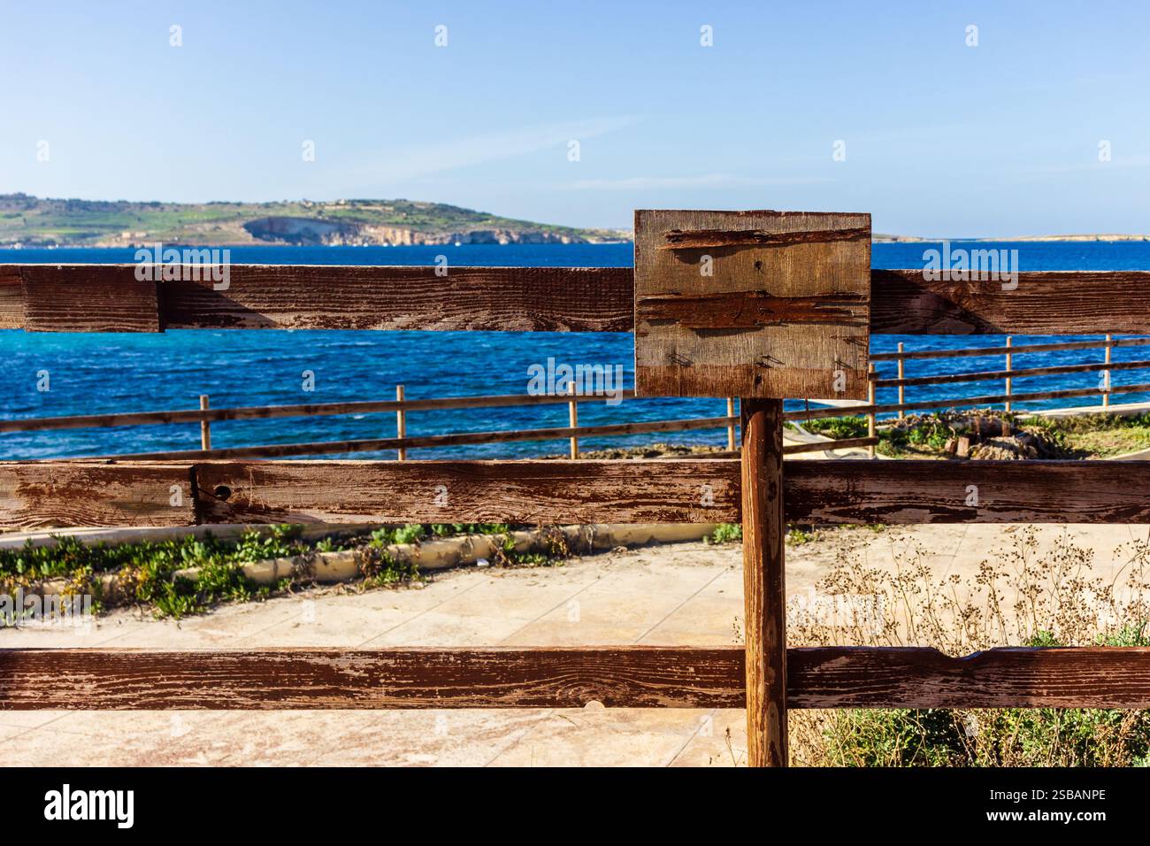 Recinto rustico in legno che si affaccia su un tranquillo Oceano con scogliere lontane Foto Stock