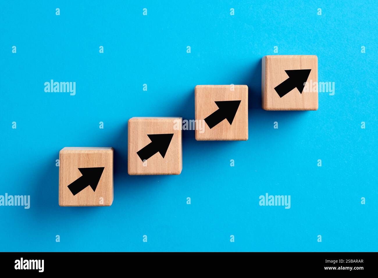 Concetto di crescita e miglioramento aziendale, finanziario, di performance o di carriera. Icone freccia ascendente gradini di blocchi di legno. Foto Stock