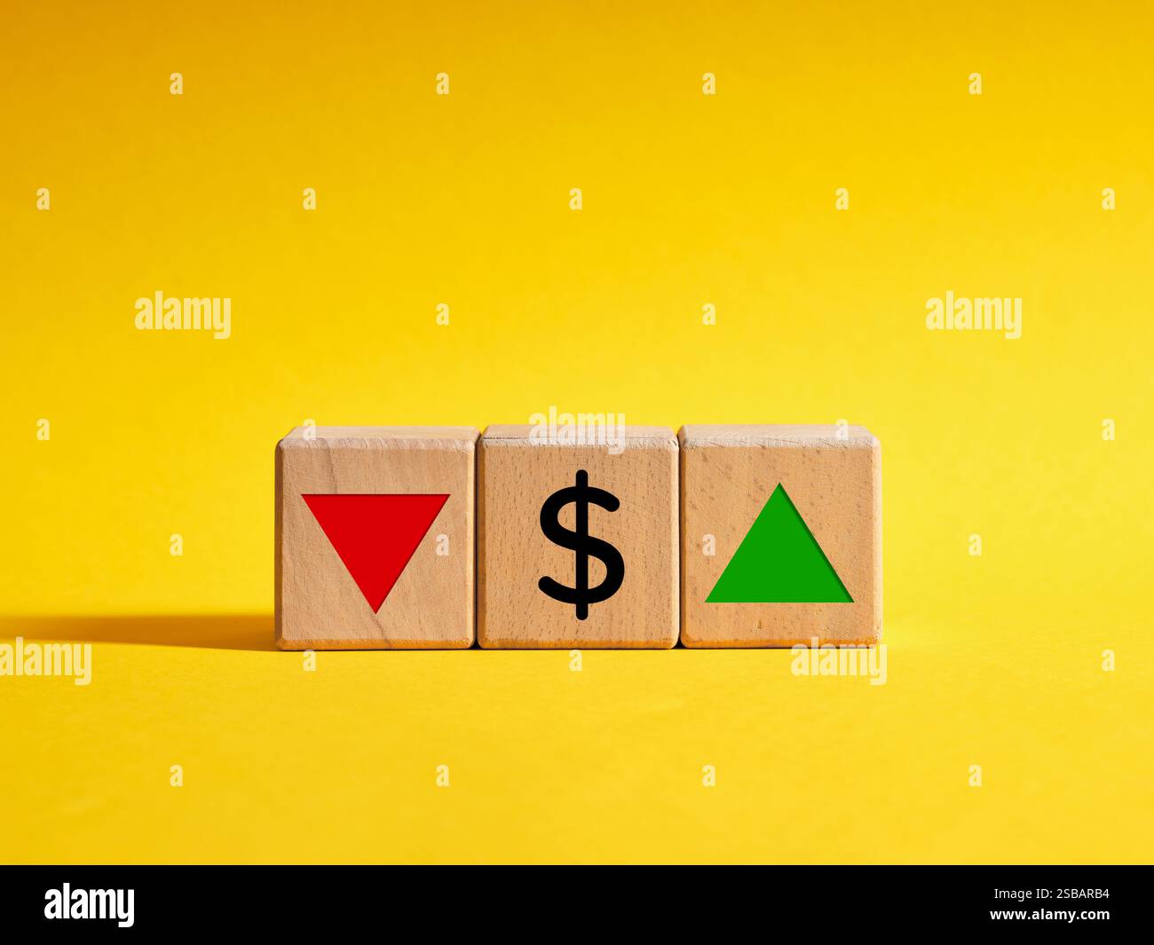 Il cambiamento dell'andamento della valuta statunitense o del dollaro aumenta o diminuisce. Cubi di legno con il simbolo del dollaro USA e le frecce rivolte verso l'alto e verso il basso. Foto Stock