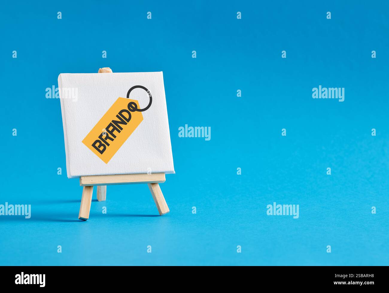 Portachiavi con la parola brand su un cavalletto su sfondo blu. Branding, creazione del marchio, riconoscimento o consapevolezza, concetto di marketing aziendale. Foto Stock