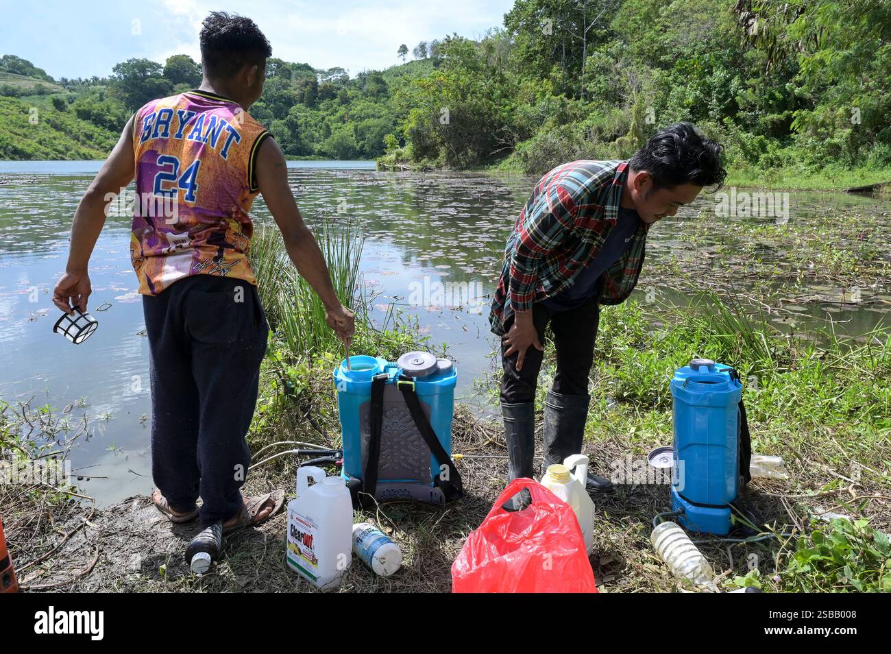 FILIPPINE, Isola di Mindanao, Kidapawan, cocktail erbicida da da operaio mescolato con glifosato nel piccolo lago per preparare una spruzzatura nel vicino campo di mais Foto Stock