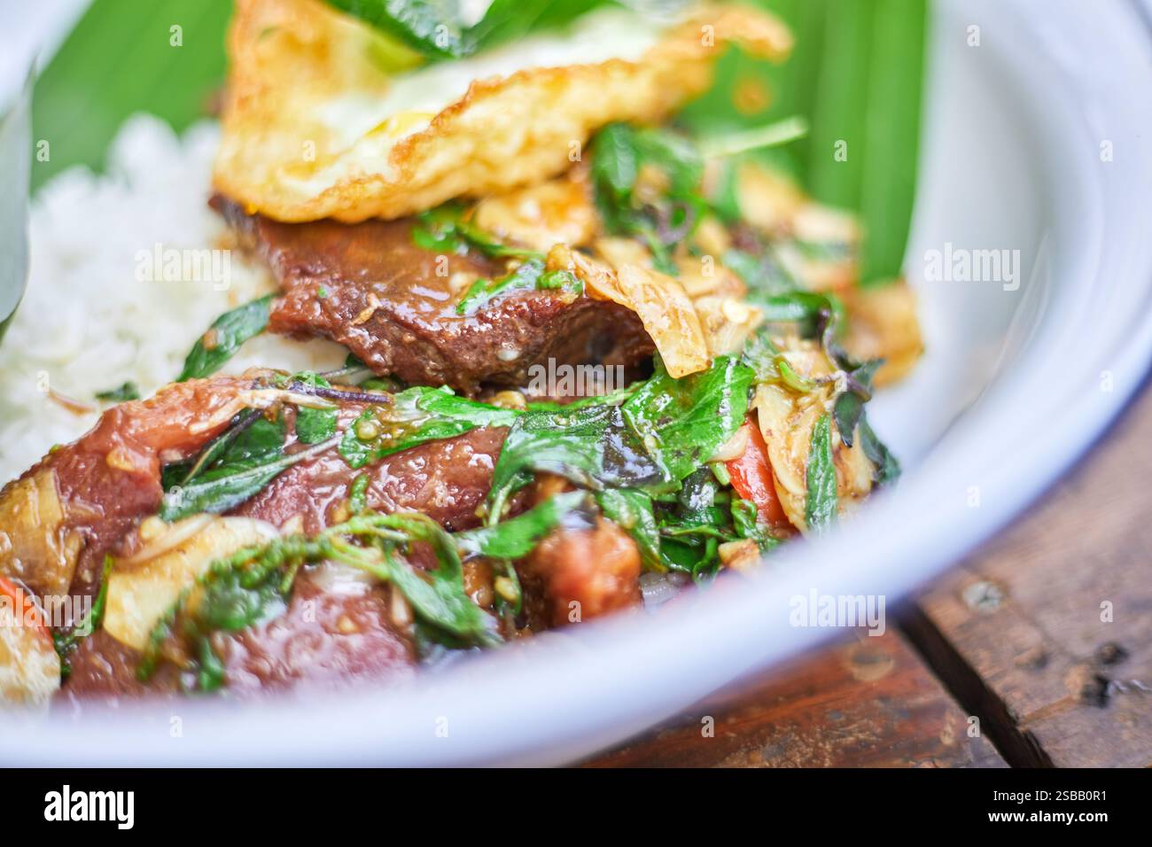 Pad Kra Pao. Frittura in padella di manzo di basilico in stile tailandese con uova fritte. Menu di piatti thailandesi Foto Stock