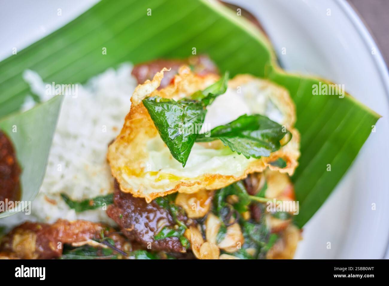 Pad Kra Pao. Frittura in padella di manzo di basilico in stile tailandese con uova fritte. Menu di piatti thailandesi Foto Stock