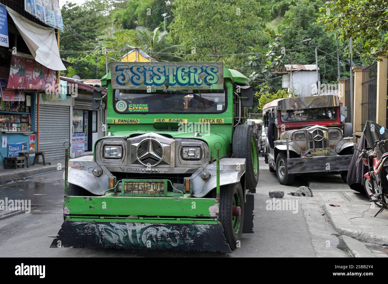 FILIPPINE, Manila, Quezon City, Payatas, Jeepney, furgoni e camion colorati personalizzati utilizzati come veicoli pubblici per i trasporti pubblici, con Mercedes Benz stella del marchio automobilistico tedesco Foto Stock
