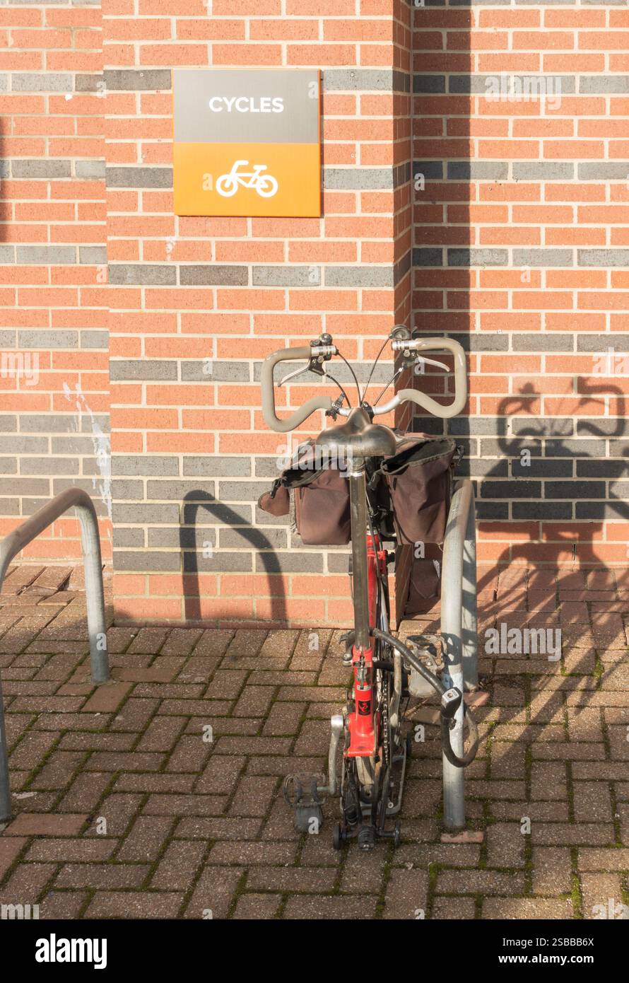 Una bicicletta pieghevole fissata a un cavalletto di tipo Sheffield Stand, Inghilterra, Regno Unito Foto Stock