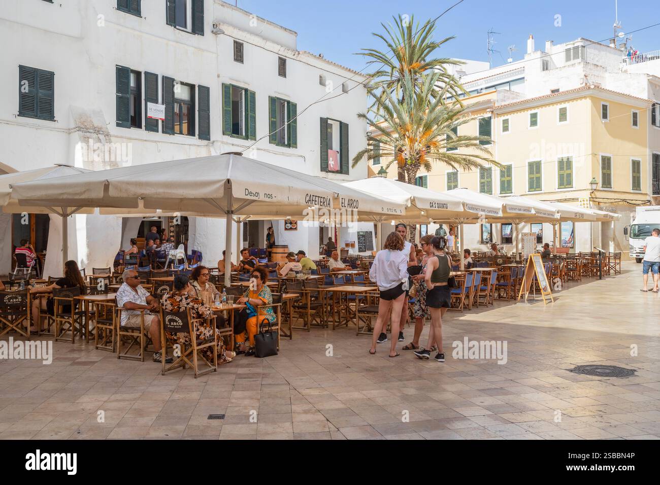 La gente gode del bel tempo sulla terrazza nel centro di Ciutadella de Menorca. Foto Stock