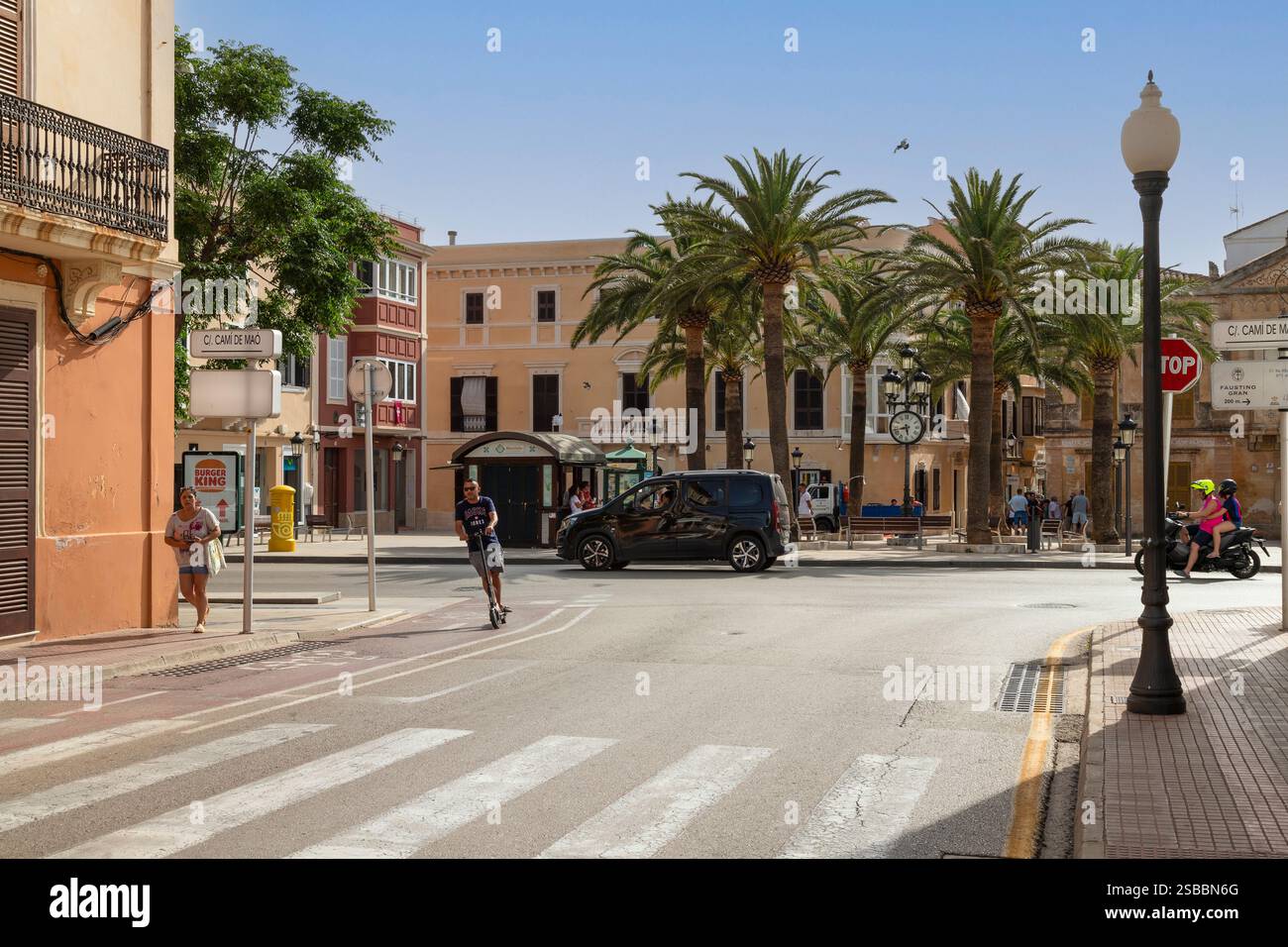 Accogliente piazza - Plaza de Alfonso III, con palme nel centro della storica città di Ciutadella sull'isola spagnola di Minorca. Foto Stock