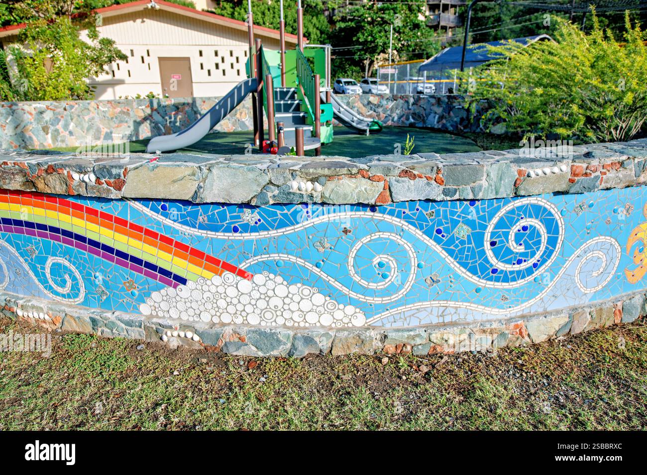 CRUZ BAY, Isole Vergini americane: Colorate piastrelle a mosaico con motivi di sole e barriera corallina decorano un parco giochi pubblico. L'installazione artistica combina temi marini con elementi di design giocosi. Il mosaico aggiunge carattere locale a questo spazio ricreativo della comunità. Foto Stock