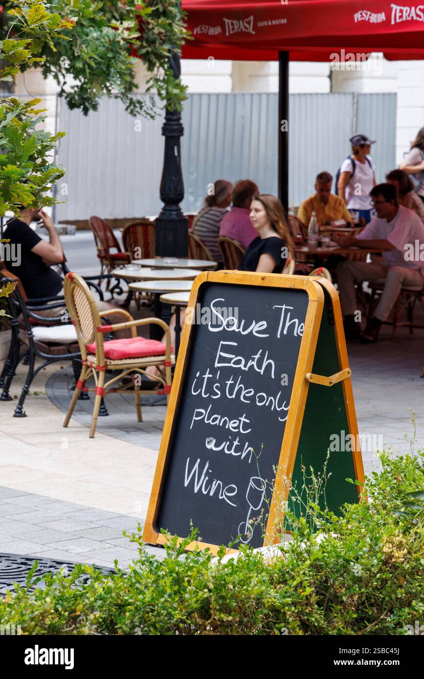 Caffè all'aperto con l'insegna "Save the Earth" che vende vino, Budapest, Ungheria Foto Stock