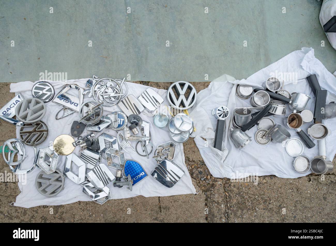 Hunedoara, Romania - 25 gennaio 2025: Folla di persone e oggetti vari, giocattoli, utensili ed elettronica in un mercato delle pulci. Foto Stock