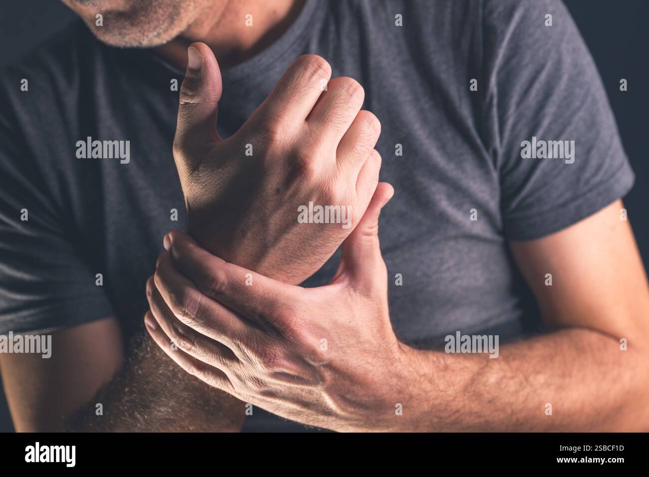 Sintomi gravi di dolore al polso, uomo con condizioni mediche dolorose, fuoco selettivo Foto Stock