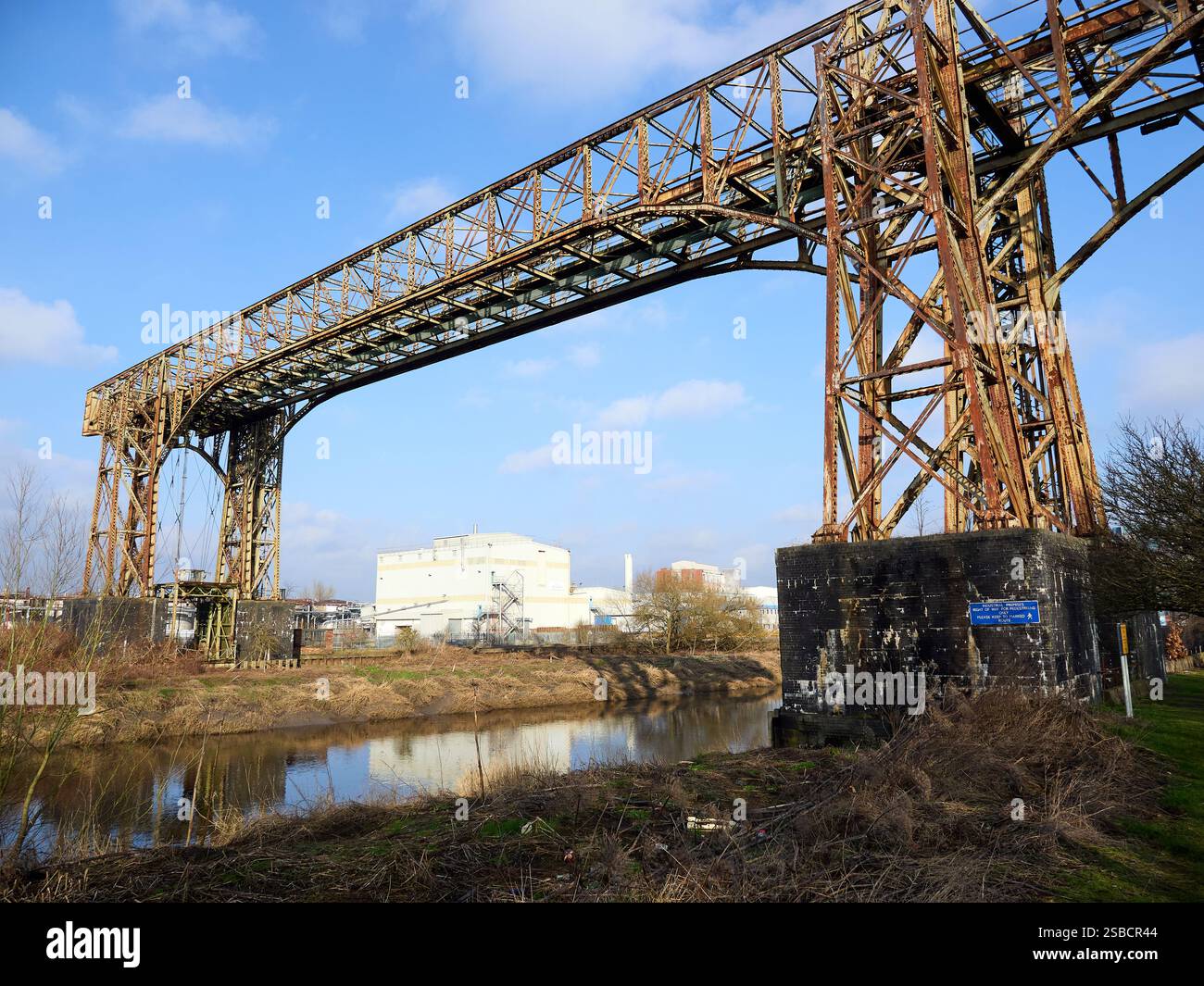 Lo storico ponte trasportatore di Warrington, che attraversa un fiume tranquillo sotto un cielo blu. Foto Stock