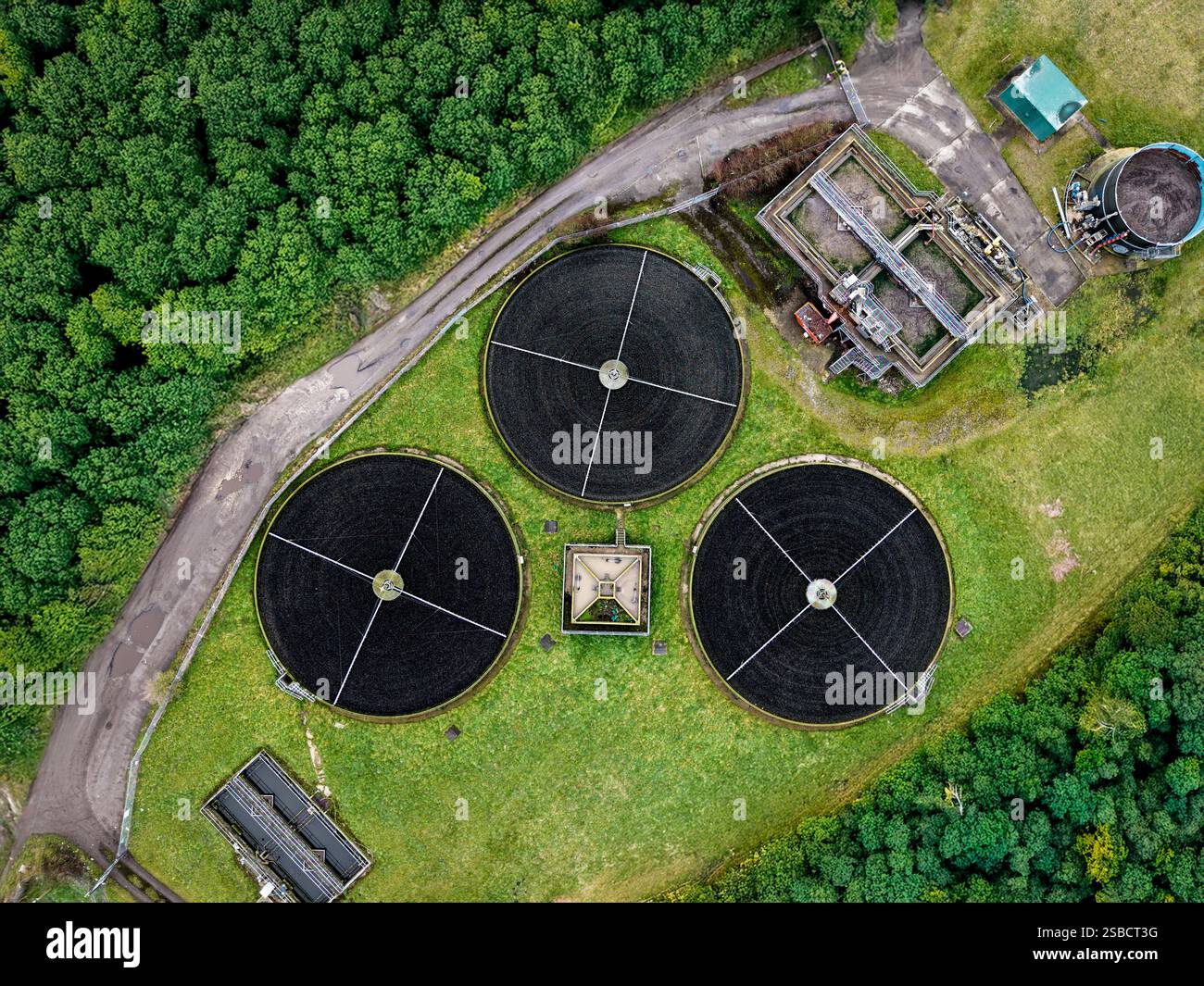Una vista aerea direttamente sopra un trattamento delle acque reflue funziona con serbatoi di stoccaggio circolari che filtrano le acque reflue per l'acqua potabile Foto Stock