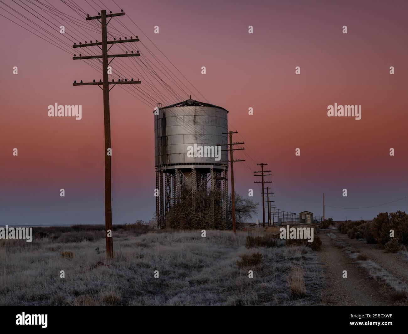 I colori del mattino decorano il cielo con una torre d'acqua su rotaia Foto Stock