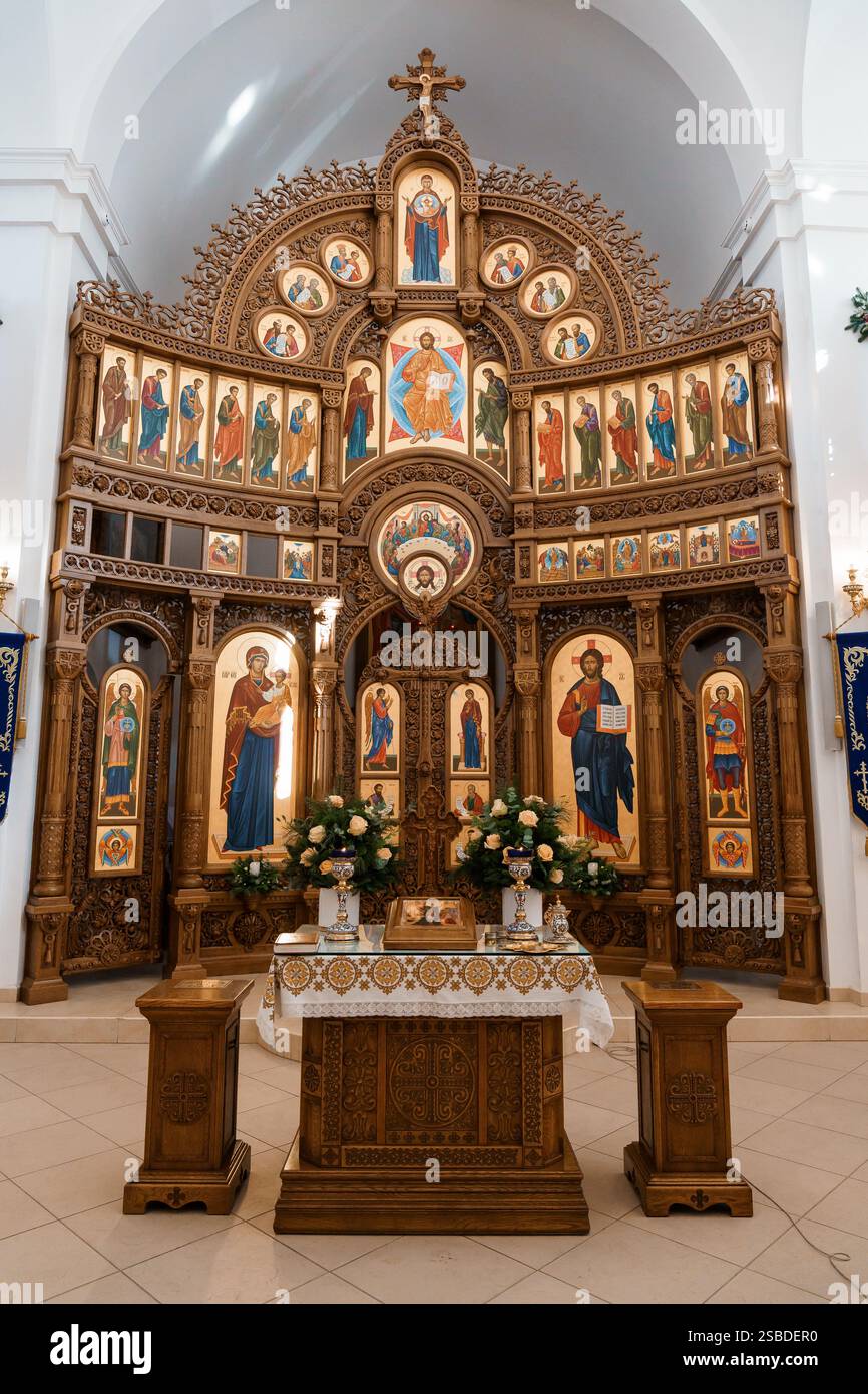 Intricato altare in legno con iconografia all'interno di una chiesa. Foto Stock