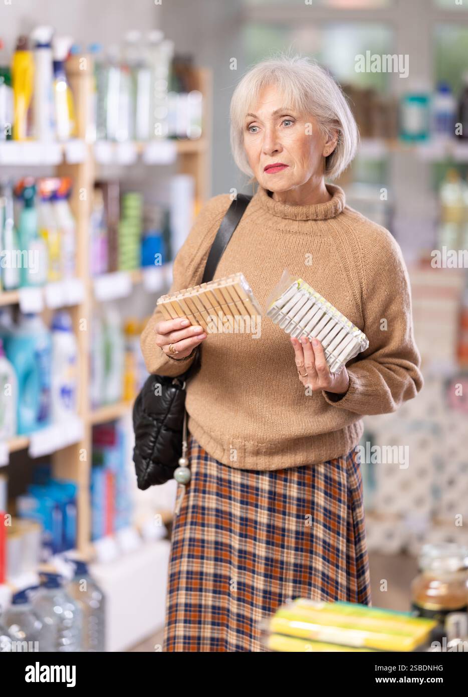 Donna che sceglie un set di clothespins nel negozio Foto Stock