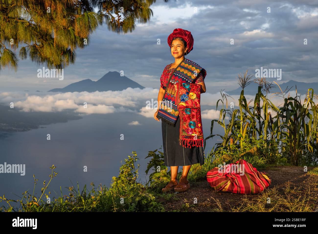 Donna che posa in abiti tradizionali maya a Mario Mendez Montenegro di fronte al lago Atitlan vicino a Santa Catarina Palopó, Guatemala Foto Stock