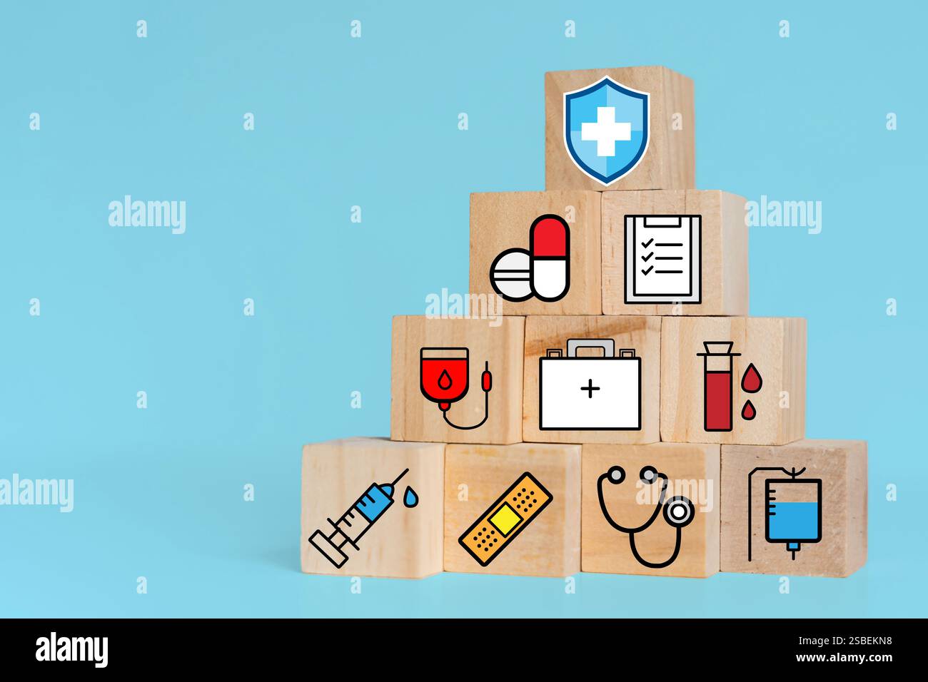 Concetto di assicurazione sanitaria e assistenza medica. Un insieme di blocchi di legno che mostrano icone relative alla salute, assistenza medica, assicurazione sanitaria e farmaci. ciao Foto Stock