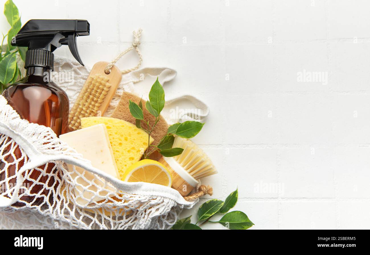 Prodotti e utensili per la pulizia naturali in sacchetto in rete su sfondo bianco per uno stile di vita sostenibile Foto Stock