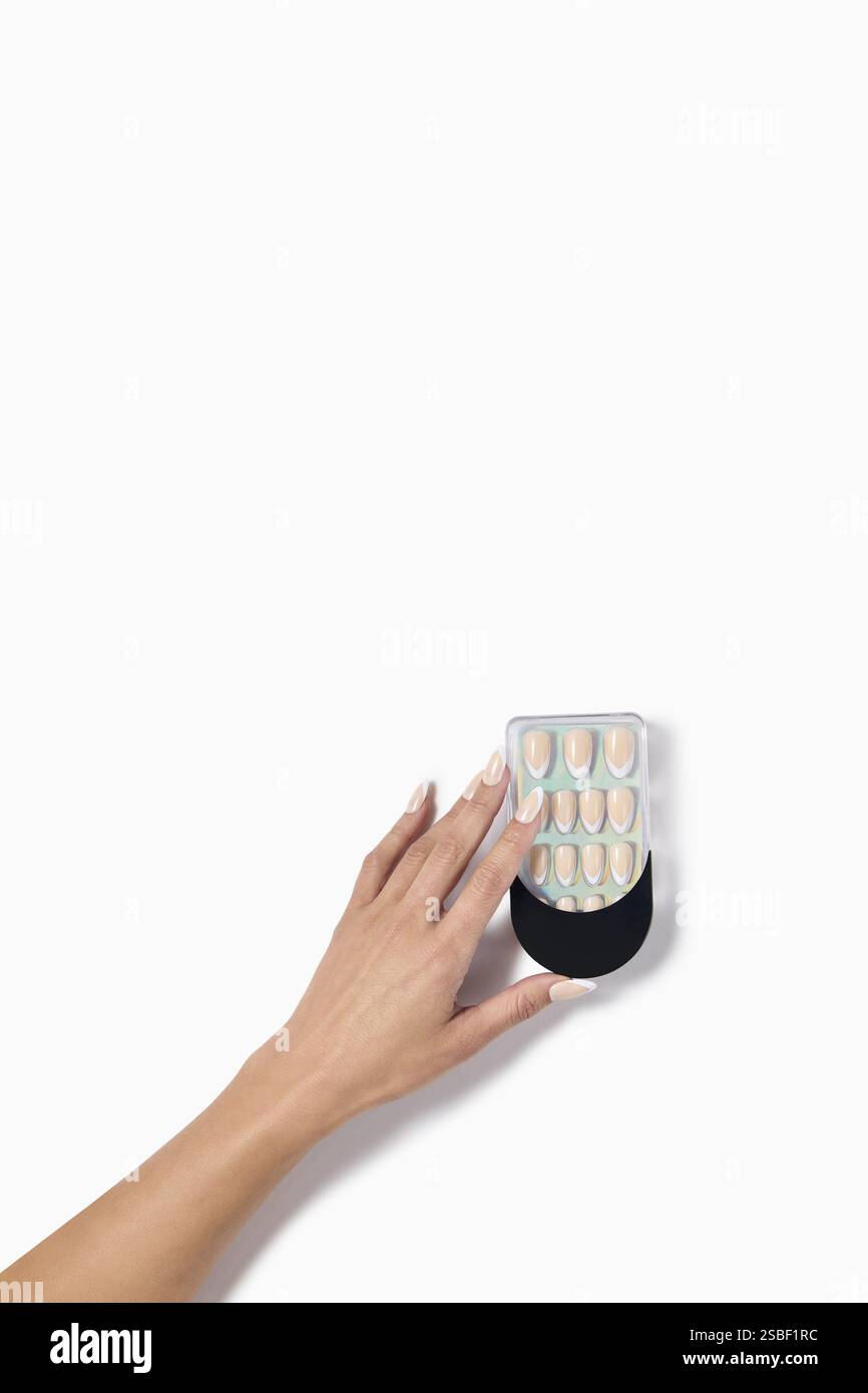 donna mano con unghie finte dopo salone di bellezza su sfondo bianco. unghie finte o false con percorso di ritaglio. Design artistico delle unghie sulle dita. Foto Stock