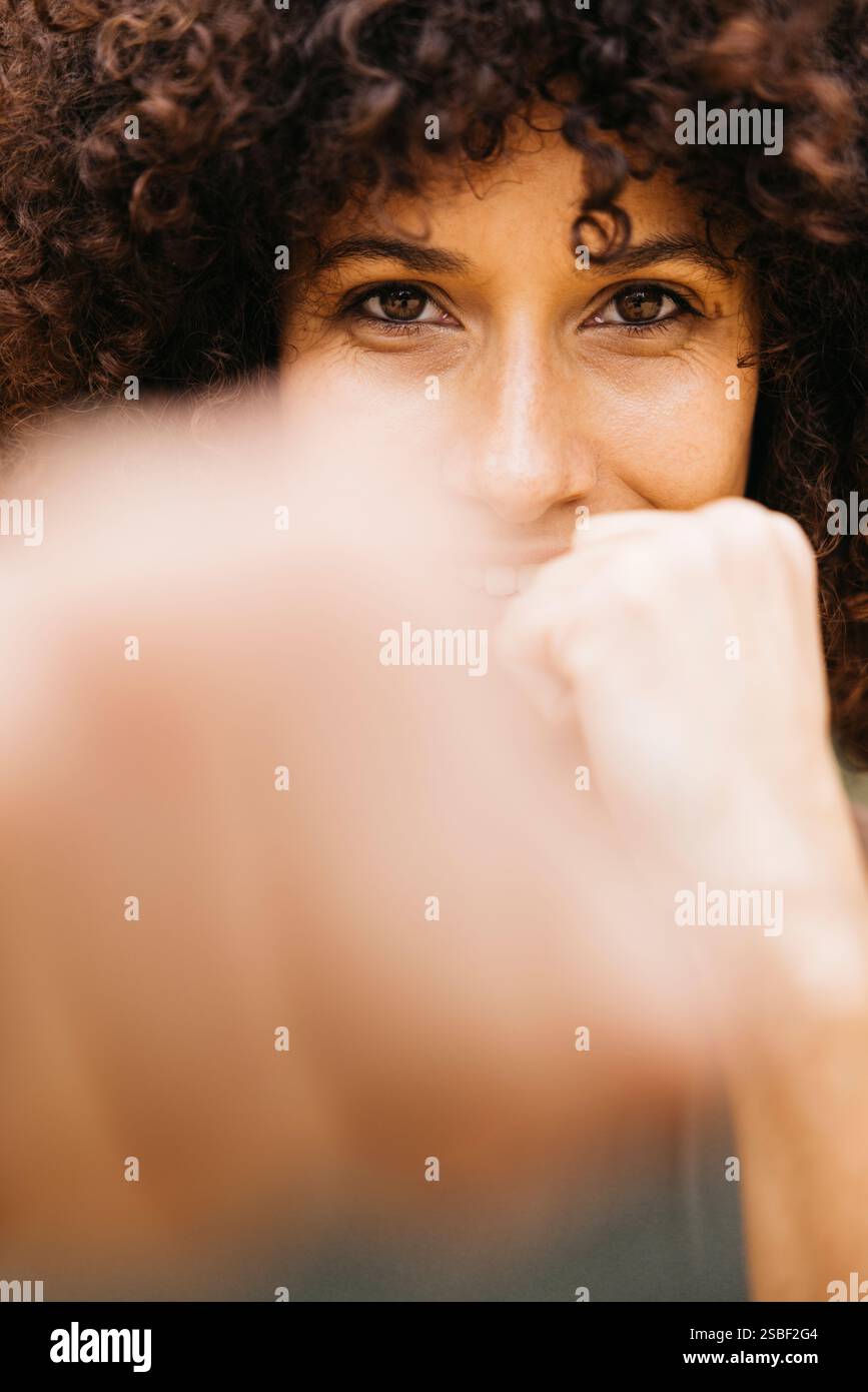 Ritratto di una giovane donna in una posizione di pugilato che mostra forza, determinazione e concentrazione durante una sessione di allenamento all'aperto. Foto Stock