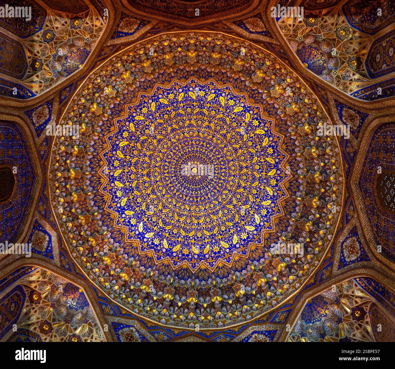 Una splendida vista di una cupola dal design complesso caratterizzata da motivi geometrici e colori vivaci, che presenta una miscela di blu, oro e piastrelle complesse Foto Stock