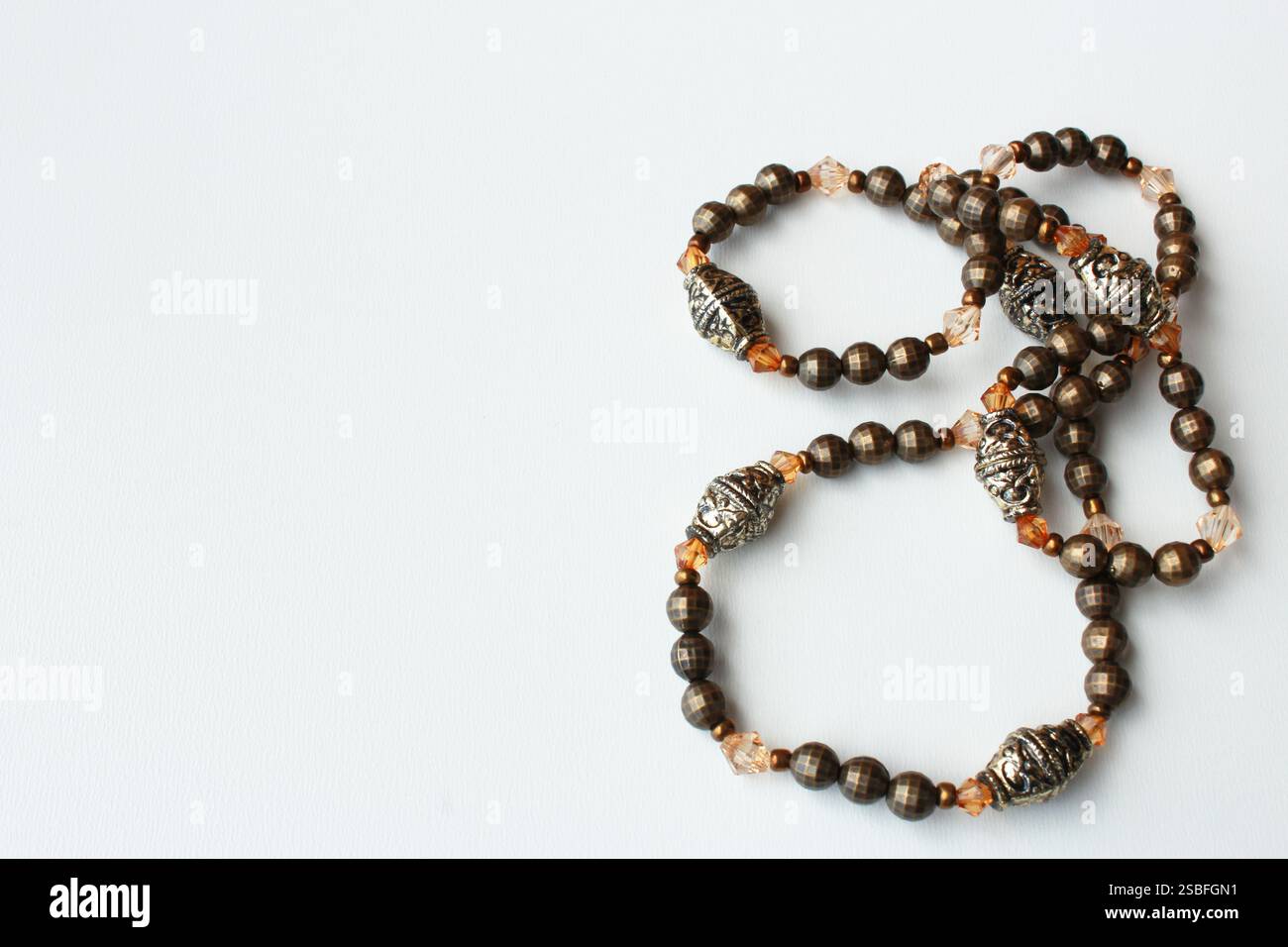 Sfondo orizzontale con spazio copia che mostra una collana vintage da donna con perline marroni. Accessorio di moda personale, bigiotteria, gioielli fatti a mano. Foto Stock