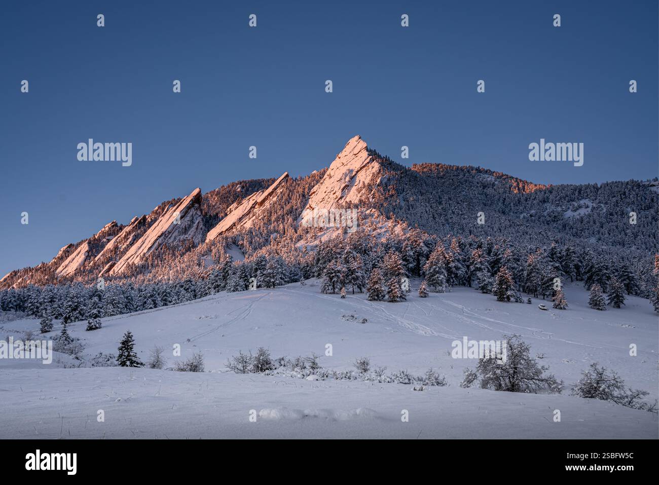 L'alba risplende sui Boulder flatirons dopo una tempesta di neve Foto Stock