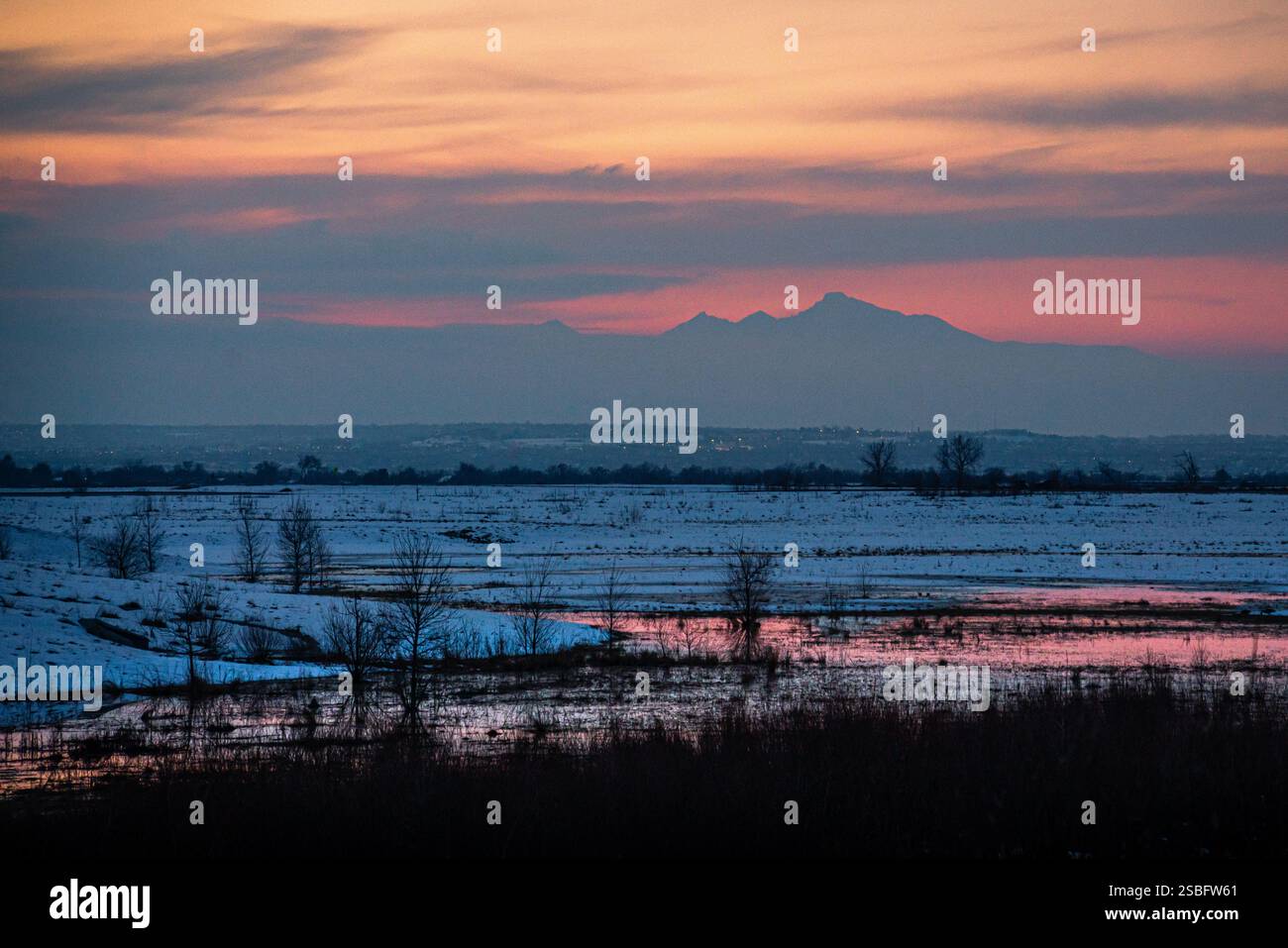 Tramonto invernale in montagna con riflessi del cielo rosa in un piccolo laghetto Foto Stock