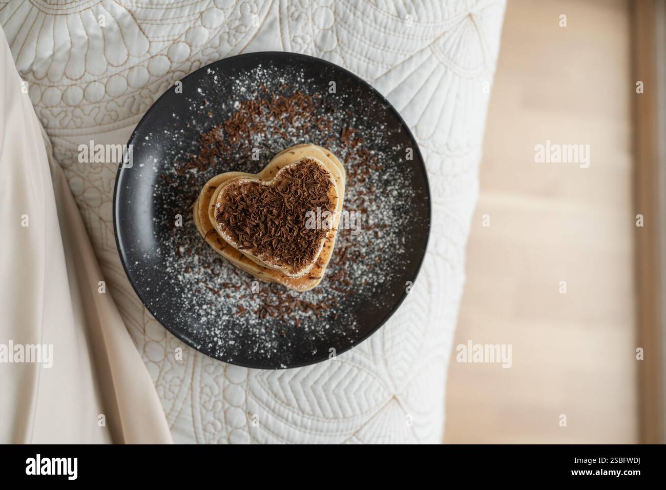 Pancake a forma di cuore con vista dall'alto su sfondo neutro Foto Stock