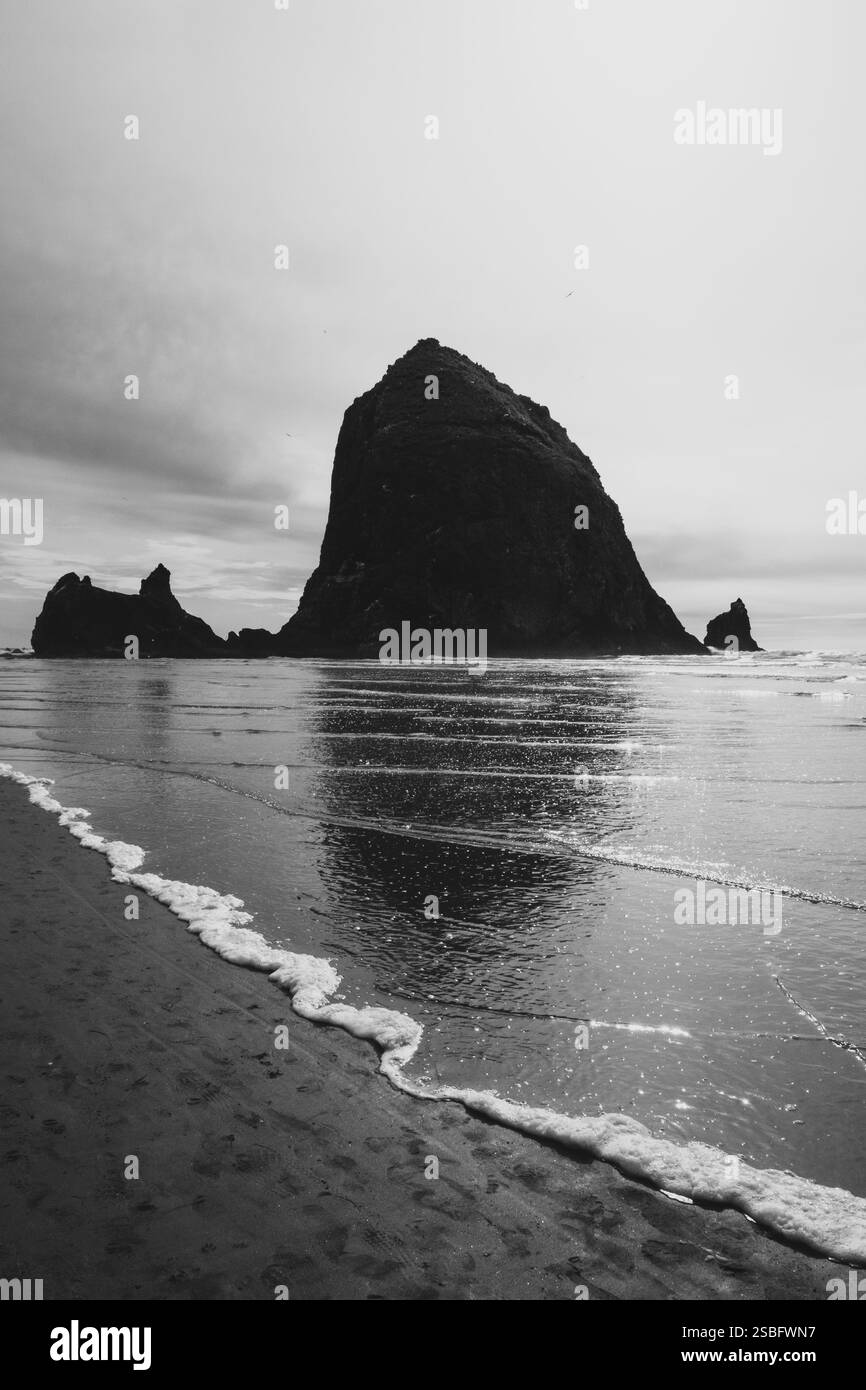 Roccia di pagliaio riflessa sulle rive di Cannon Beach Foto Stock Roccia di pagliaio riflessa sulle rive di Cannon Beach Foto Stock