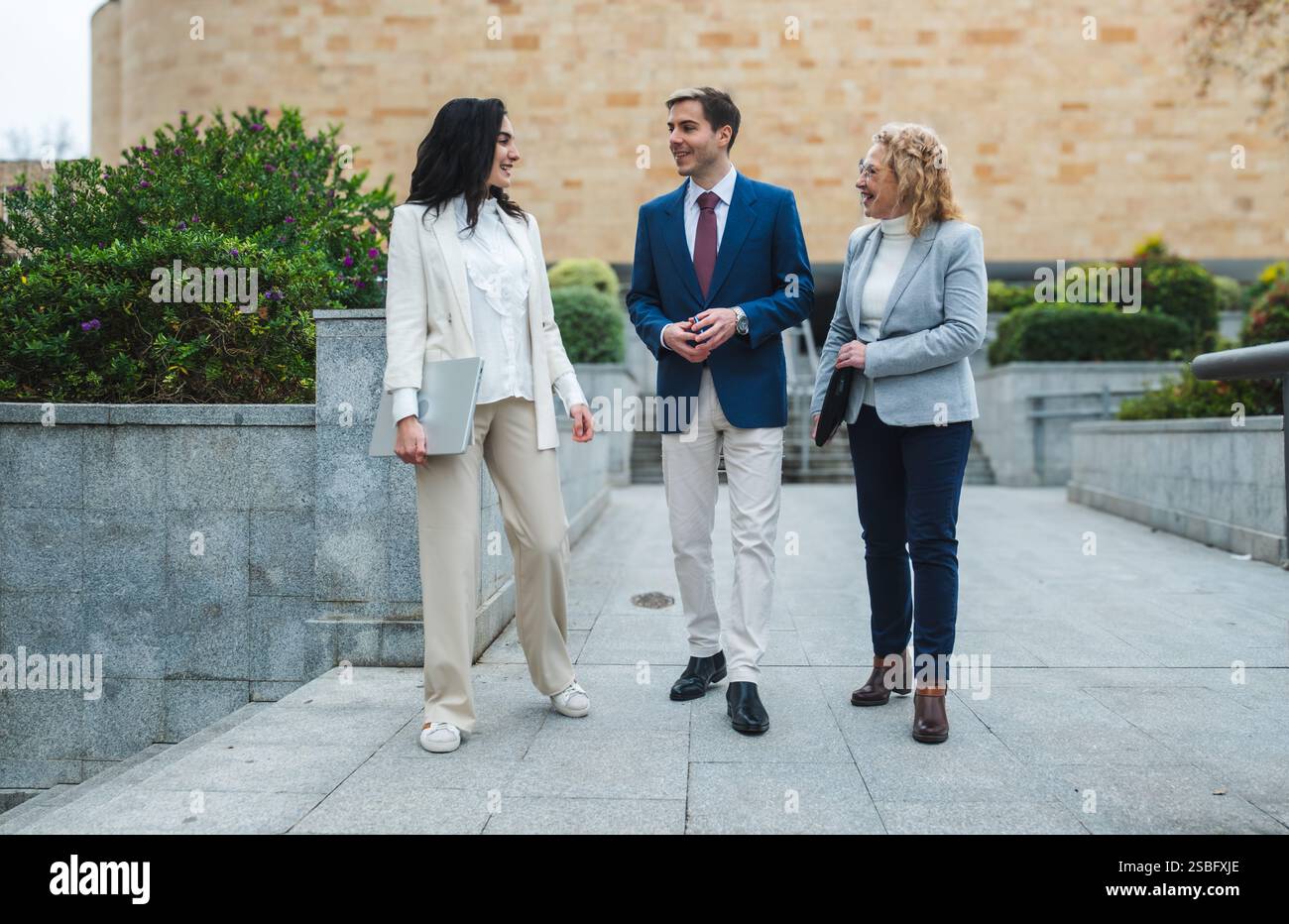 Uomini d'affari che camminano e parlano all'aperto nella città moderna Foto Stock