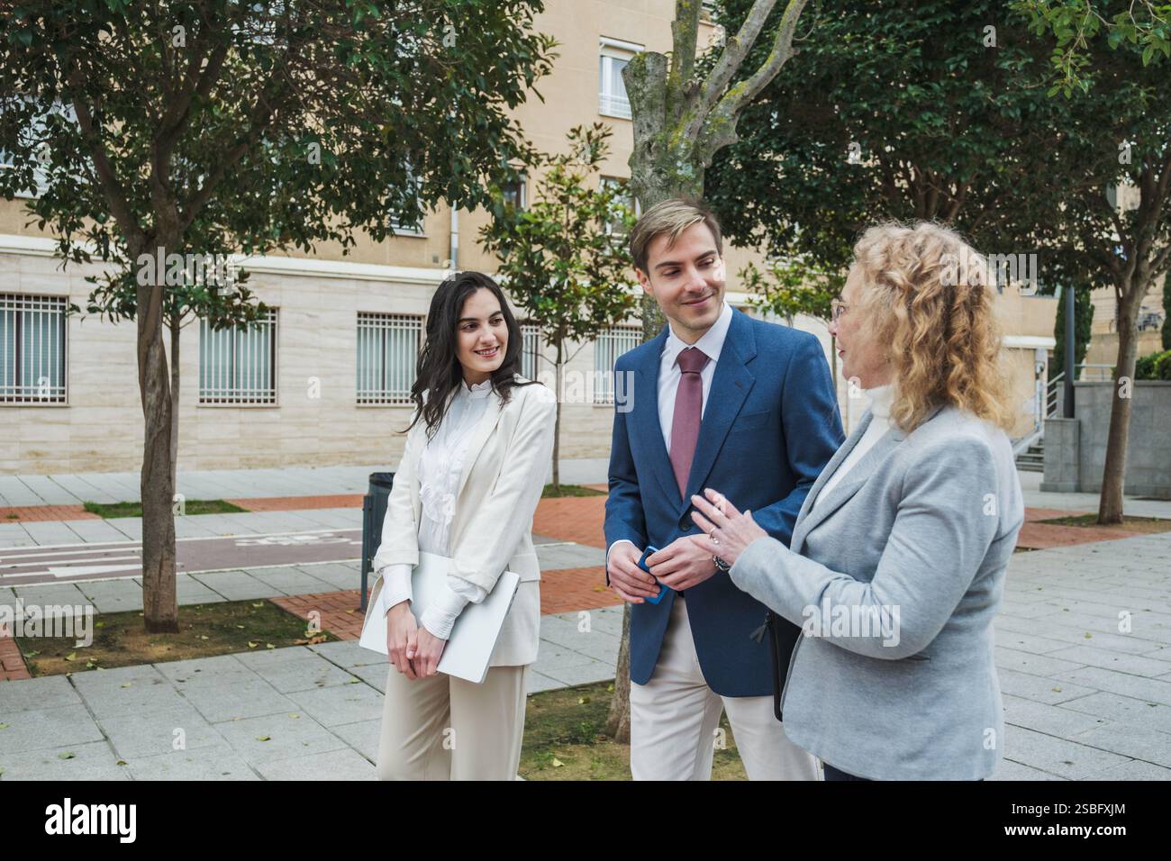 Uomini d'affari che parlano all'aperto in un ambiente urbano e discutono di lavoro Foto Stock