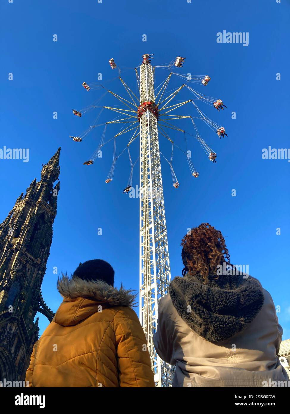 Festeggiamenti natalizi nei Princes Street Gardens con persone che guardano il giro Star Flyer al monumento Scott, Edimburgo, Scozia Foto Stock