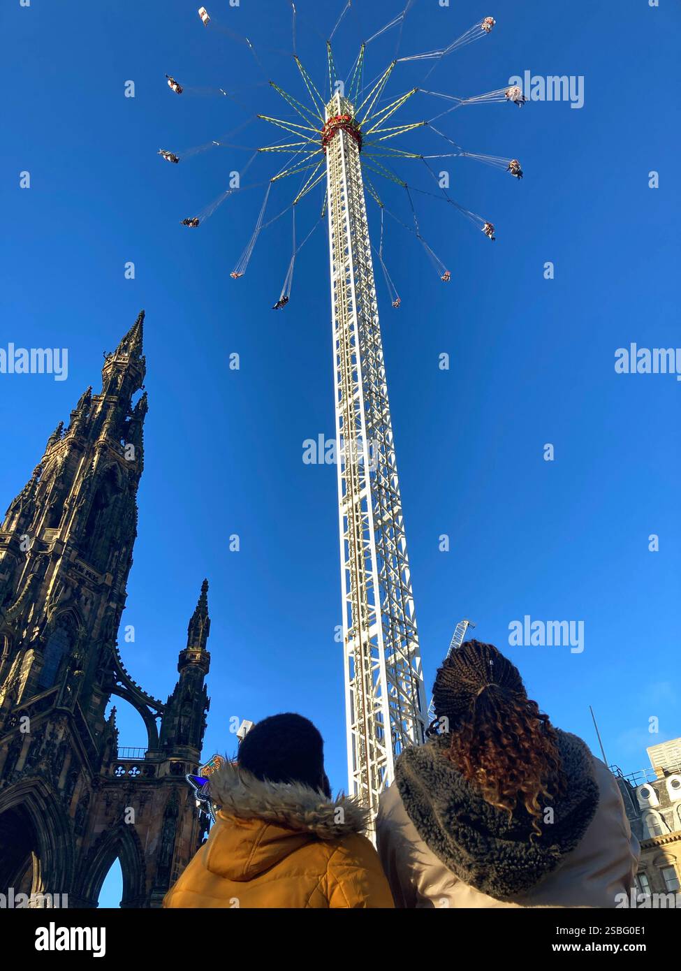 Festeggiamenti natalizi nei Princes Street Gardens con persone che guardano il giro Star Flyer al monumento Scott, Edimburgo, Scozia Foto Stock