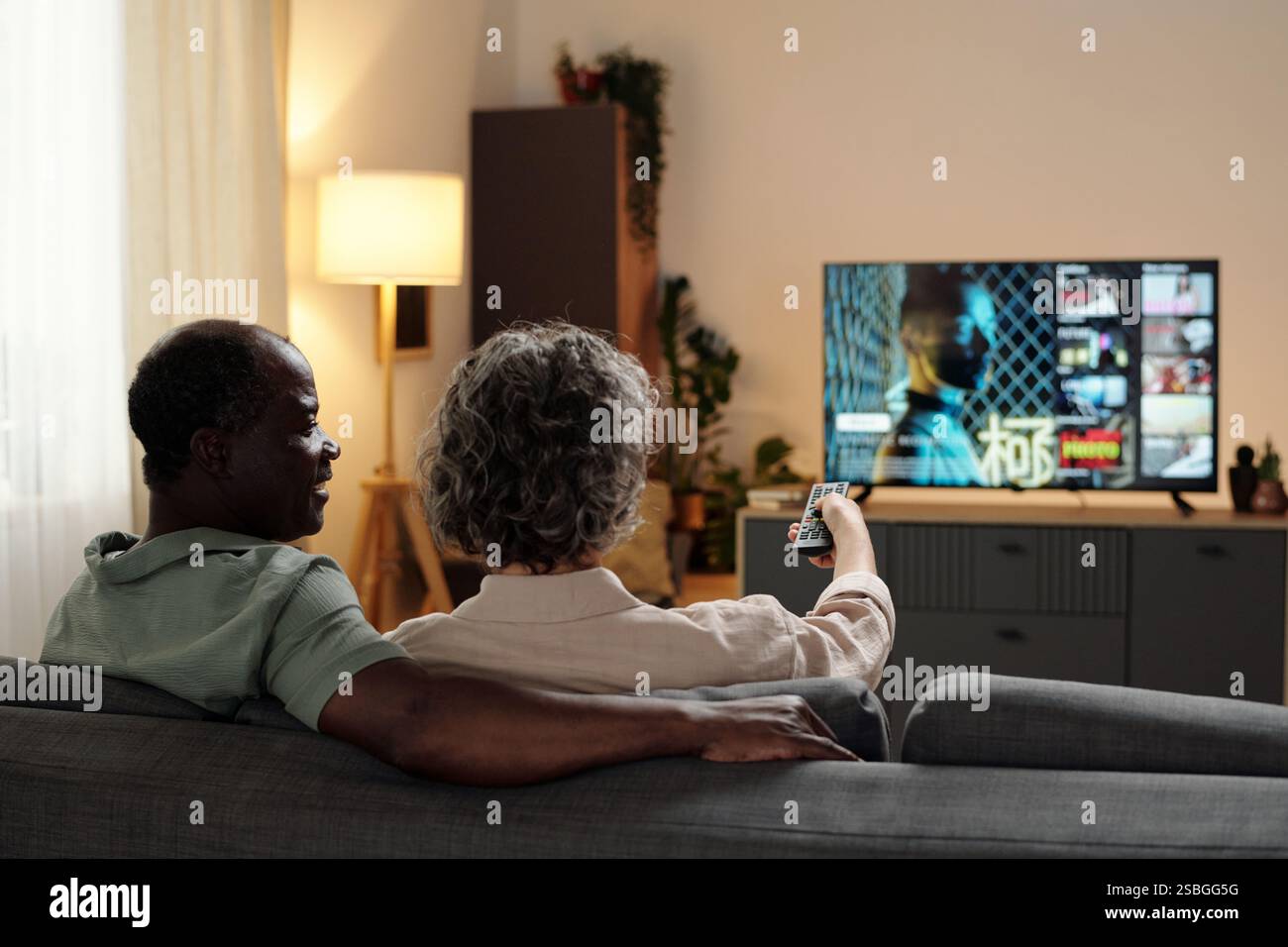 Coppia senior che guarda la televisione nel soggiorno Foto Stock
