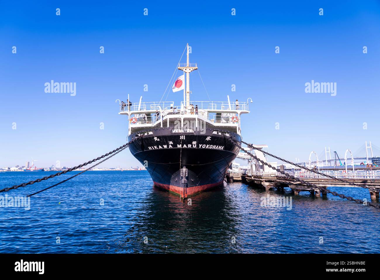 La nave da crociera Hikawa Maru attraccata nel porto di Yokohama, in Giappone, sotto un cielo luminoso, catturando la storica nave e l'atmosfera del lungomare. Foto Stock