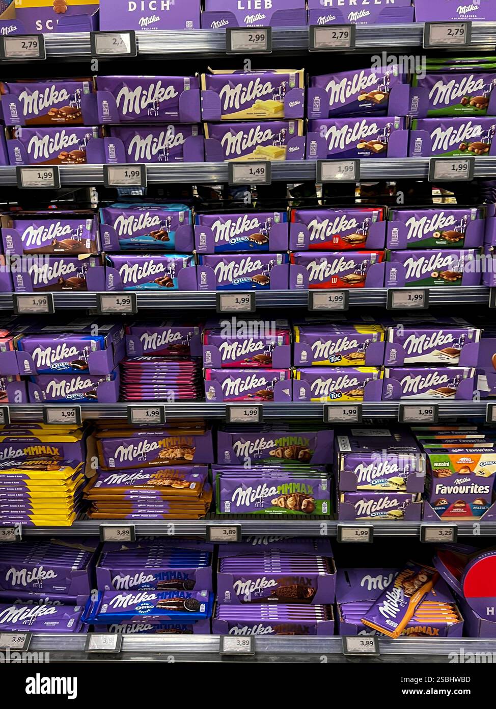 Symbolfoto - Milka Schokolade - Regale im Supermarkt Disconter mit verschiedenen Sorten Milka Alpenmich Schoholade in lilla Papier gehült mit dem Logo der Milka Kuh. Der Name ist eine Kombination der beiden Hauptzutaten Milch und Kakao. Der Kakaopreis steigt und steigt. Und das macht unsere geliebte Schoggi teurer Der US-Produzent Mondelez verkleinert zahlreiche Sorten. Drastische Preiserhöhung bei einer der bekanntesten Schokoladen-Marken Verbraucherinnen und Verbraucher müssen für Schokolade der bekannten Marke Milka derzeit vielerorts tiefer in Die Tasche greifen Mondelez International ist e Foto Stock
