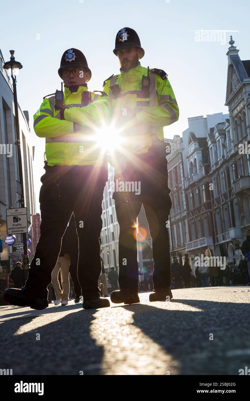 Durante le celebrazioni del capodanno cinese a Londra, due ufficiali della polizia metropolitana si sono incontrati sulla Shaftsbury Avenue in una giornata di sole con cielo e cieli blu. (143) Foto Stock