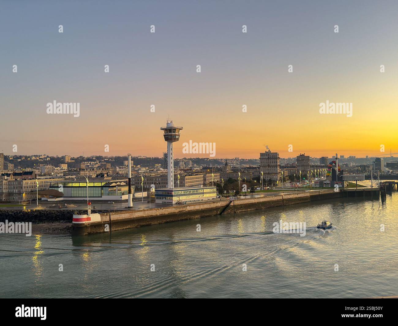 Le Havre, Francia, Europa - 16 gennaio 2025: Ingresso al porto di le Havre con la torre di controllo delle navi sul lungomare all'alba. Foto Stock