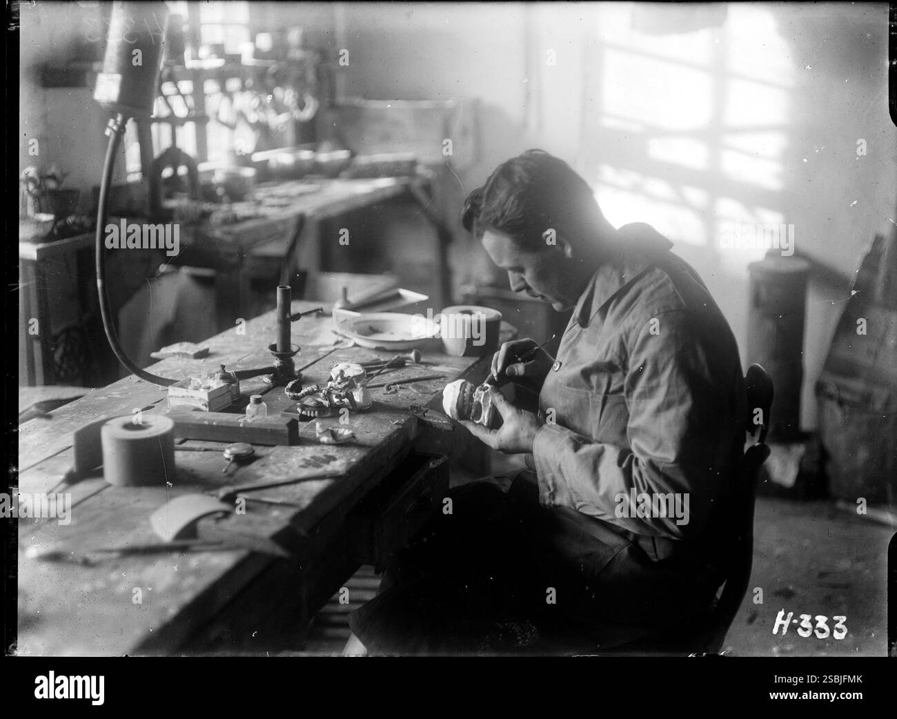 Un meccanico dentale dell'esercito aggiunge un tocco finale a una nuova serie di protesi prodotte presso il laboratorio del New Zealand Dental Corps di Nielles, in Francia. 1917 di Henry Armytage Sanders. Biblioteca Alexander Turnbull, Wellington Foto Stock