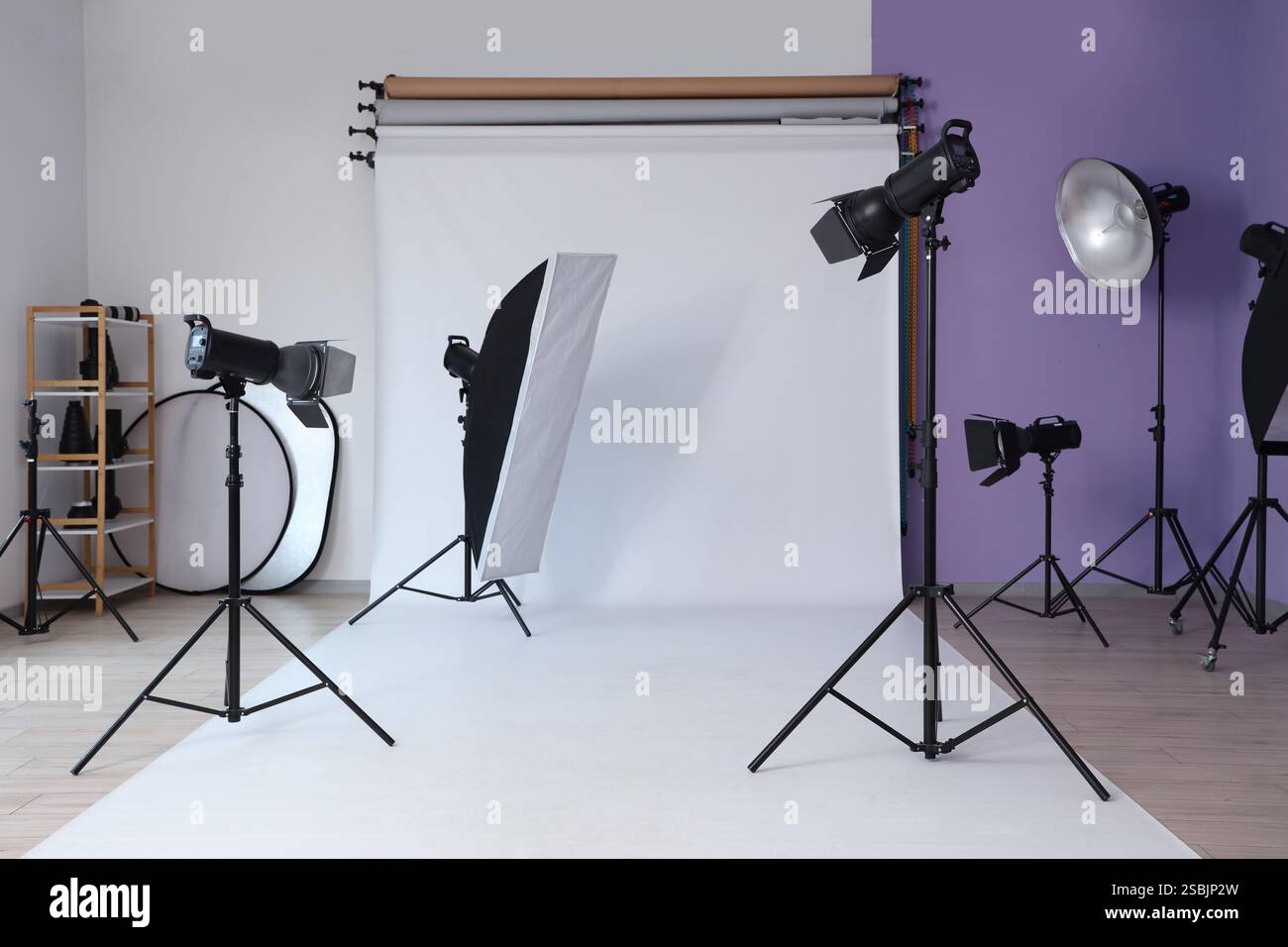Interno dello studio fotografico con attrezzature professionali e sfondo bianco Foto Stock