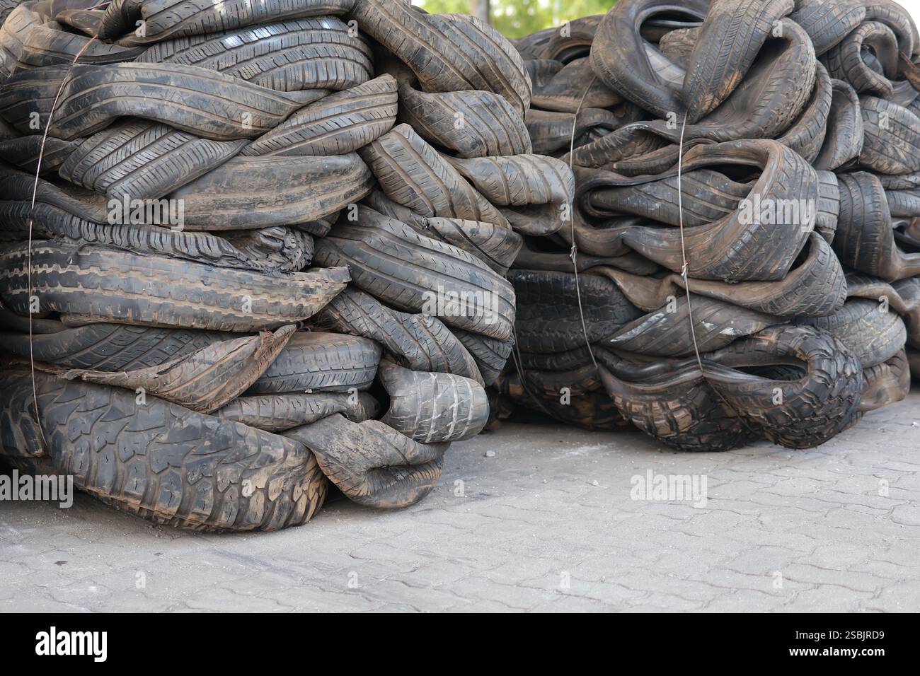 Una grande pila di pneumatici vecchi e usurati impilati insieme, che mostrano il potenziale di riciclaggio o riutilizzo in vari settori. Foto Stock